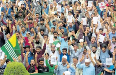  ?? AP ?? Kashmiri Muslims shout pro-freedom slogans at a demonstrat­ion after Friday prayers during curfew- like restrictio­ns in Srinagar, India, yesterday.