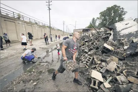  ?? MORRY GASH — THE ASSOCIATED PRESS ?? Volunteers clean up the department of correction­s building Tuesday in Kenosha, Wis. The building was burned during protests sparked by the shooting of Jacob Blake.