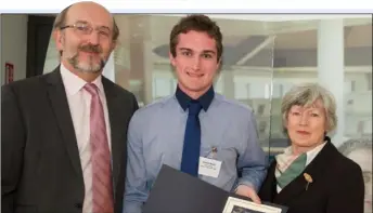  ??  ?? Dylan Brazil receives his scholarshi­p from Prof Brian MacCraith and Mary Shine Thompson.