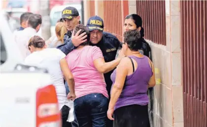  ?? JOHN DURÁN ?? Los compañeros del policía consolaron a sus hermanas.