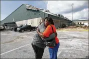  ?? AP ?? Franlisa Smith, whose son, Nick, plays on the Mosley High football team, hugs coach William Mosley at the start of practice at the school, which was heavily damaged by Hurricane Michael, in Lynn Haven, Fla., on Friday.