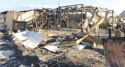  ?? (John Davison/Reuters) ?? US SOLDIERS inspect the site where an Iranian missile hit Ain al-Asad air base in Anbar province, Iraq, last January.