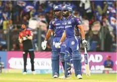  ?? Courtesy: IPL ?? Evin Lewis and Rohit Sharma of the Mumbai Indians during the match against Royal Challenger­s Bangalore in Mumbai on Tuesday. Mumbai beat Bangalore by 46 runs, courtesy Rohit’s 94 and Lewis’ 65.