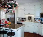  ??  ?? The kitchen offers   oor-to-ceiling cabinets, an island/breakfast bar, a desk and more.