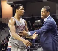  ?? Tony Tribble / Associated Press ?? UConn coach Kevin Ollie, right, talks with Christian Vital during a 2018 game against Cincinnati.