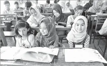  ??  ?? Pakistani students belonging to the Shiite Hazara community attend a class at a school in Hazara town, a neighbourh­ood in Quetta.