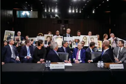  ?? Photograph: Sarah Silbiger/Reuters ?? Family members of those who died in the twin 737 Max crashes hold pictures of the victims as a congressio­nal hearing in Washington in October 2019. The former chief executive Dennis Muilenburg is front right.