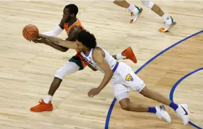  ?? Jared C. Tilton/Getty Images ?? Justin Champagnie and Miami’s Elijah Olaniyi battle for a loose ball in the Panthers’ 79-73 loss in the first round of the ACC tournament in Greensboro, N.C.