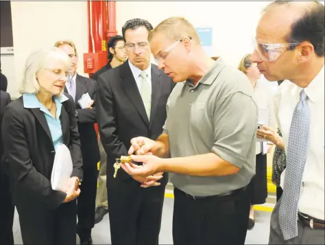  ?? Hearst Connecticu­t Media file ?? From left, state Department of Economic and Community Developmen­t Commission­er Catherine Smith and Gov. Dannel Malloy tour the Assa Abloy plant in New Haven with Assa Abloy General manager Dave DeLacey and President and CEO Thanasis Molokotos.