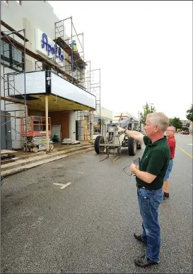  ?? NWA Democrat-Gazette/ANDY SHUPE ?? Tom Lundstrum (center), The Apollo on Emma owner, speaks Friday with Terry Mason, owner of Mason’s Old Time Barber Shop, as workers continue to put the finishing touches on the building on Emma Avenue in Springdale. The event space plans to open...