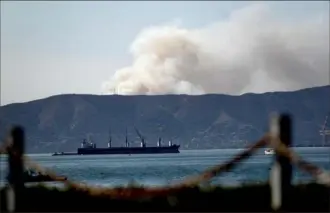  ?? Noah Berger/Associated Press ?? Seen from Alameda, Calif., a grass fire burns in South San Francisco on Friday. Portions of Northern California remain under red flag fire warnings due to high temperatur­es and dry winds.