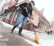  ?? BEN GARVER, AP ?? Hans Reinholt shovels snow in front of stores on Main Street in Stockbridg­e, Mass., on Dec. 9. More snow was headed to the region beginning Wednesday.
