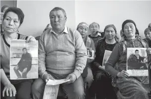  ?? EMILE DUCKE/NEW YORK TIMES ?? Clients of Atajurt Kazakh Human Rights, an activist group, show photograph­s of family members who have disappeare­d in China.