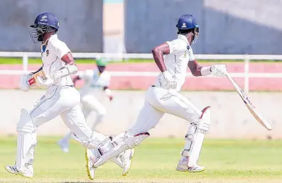  ?? PHOTO BY LENNOX ALDRED ?? Kraigg Brathwaite (left) and Kevin Wickham of Barbados Pride take a quick single during day two action of their West Indies Championsh­ip match against the Jamaica Scorpions at Sabina Park yesterday.