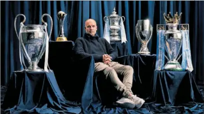  ?? ?? Pep Guardiola posa con sus últimos títulos: Champions, Mundial de Clubes, FA Cup, Supercopa y Premier.