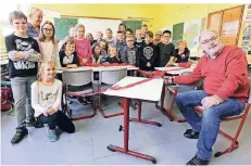  ?? FOTO: UWE MISERIUS ?? Die Schüler der GGS Uferstraße freuen sich über die neuen Tische, die die Stiftung des Leichlinge­rs Jürgen Vogel (r.) mitfinanzi­ert hatte.