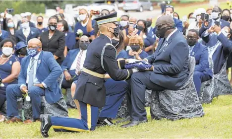  ?? POOL/GETTY IMAGES ?? A member of the Honor Guard presents the American flag that was on the casket of the late Rep. John Lewis to his son, John-Miles Lewis.