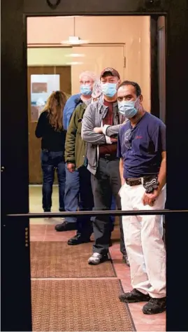  ?? ANTONIO PEREZ/CHICAGO TRIBUNE ?? Margarito Avelar and his colleagues at Ferrara Candy line up to receive their Moderna COVID-19 vaccine April 15 at the company’s plant in Chicago.