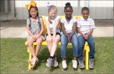  ?? Kaitlyn Rigdon/News-Times ?? Buddy bench: From left, Carolina Sneed, Annalee Ibert, Brayden Minor and Jalea Strickland sit on the new “buddy bench” located at Yocum Primary School. The buddy bench is a simple idea to eliminate loneliness and foster friendship and include kindness...