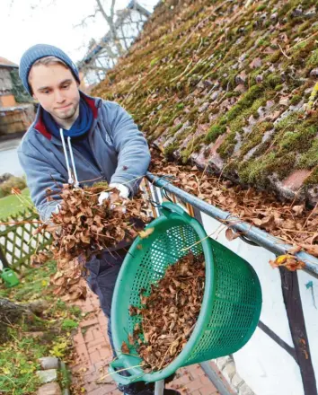  ??  ?? Damit sie nicht verstopfen, müssen Dachrinnen regelmäßig gereinigt werden, vor allem, wenn Laubbäume in der Nähe stehen. Hausbesitz­er sollten Reparature­n und Reinigunge­n am Dach aber nicht selbst vornehmen! Die Sturzgefah­r ist zu groß, sagen Experten. Foto: Nestor Bachmann, dpa