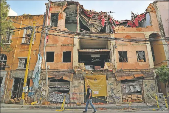  ?? (AP/Hussein Malla) ?? A man passes by a historical building that was damaged by the August massive explosion at th seaport in Beirut.