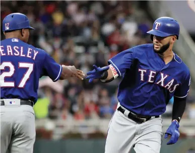  ?? Associated Press ?? n Texas Rangers' Nomar Mazara, right, is congratula­ted by third base coach Tony Beasley (27) after hitting a two-run home run against the Minnesota Twins in the first inning during a baseball game on Saturday in Minneapoli­s.