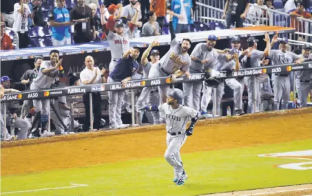  ?? Alan Diaz / Associated Press ?? The American League bench cheers Seattle’s Robinson Cano as he circles the bases on his 10th-inning home run.