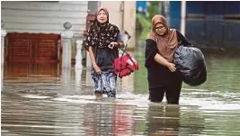  ?? (Foto Rafi Mamat/bh) ?? Maznah (kiri) berpindah selepas rumah di Kampung Sungai Belat ditenggela­mi banjir pada 11 Disember lalu.