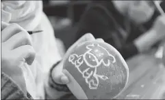  ?? PROVIDED TO CHINA DAILY ?? Above: An artist carves a bull pattern on a radish lamp for Lantern Festival.