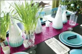  ?? KRISTINA CRESTIN VIA AP ?? This undated photo provided by Massachuse­tts-based interior designer Kristina Crestin shows a table setup by Crestin. To add some unexpected sparkle to a holiday table, Crestin used sheets of raspberry-colored metallic craft paper as a table runner...