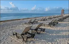  ?? Victor Ruiz/Associated Press ?? Lounge chairs fill an empty beach in Cancun, Mexico.