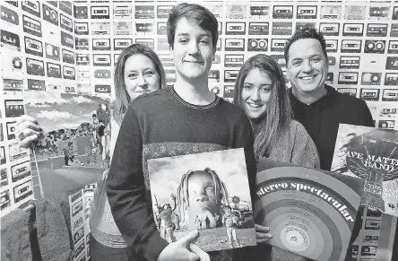  ?? JOSH T. REYNOLDS FOR USA TODAY ?? Shay Toland, left, and her children, Aidan, 17, Maeve, 15, and and husband Brian with albums in front of tape cassette wallpaper at their home, examples of how so many old- school items are back in vogue.