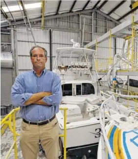  ?? AP PHOTO/CHRIS O’MEARA ?? Peter Truslow, Chief Executive Officer for Bertram, a boat building company, poses near three of his custom made boats in Tampa, Fla.