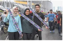  ?? — Bernama ?? Lucky trio: Harimau Malaya supporters showing off their tickets at the stadium.