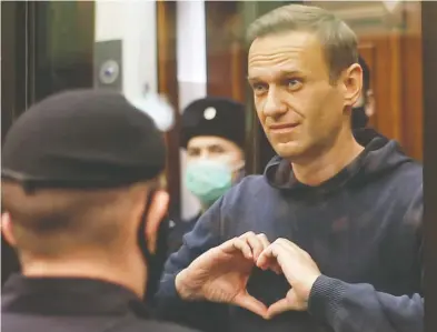  ?? PRESS SERVICE OF SIMONOVSKY DISTRICT COURT / HANDOUT VIA REUTERS ?? Russian opposition leader Alexei Navalny, who is accused of flouting the terms of a suspended sentence for seeking
medical care in Germany after being poisoned, making a heart gesture in court in Moscow on Tuesday.