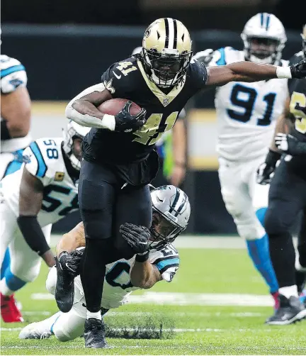  ?? SEAN GARDNER/GETTY IMAGES ?? New Orleans Saints running back Alvin Kamara gets tackled from behind by Carolina Panthers safety Kurt Coleman in the second half on Sunday in New Orleans. Kamara scored two touchdowns in Sunday’s win, and now has TDs in six straight games.