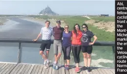  ??  ?? Abi, centre, and fellow cyclists in front of the Mont-StMichel, marking the end of the Veloscenic cycling route in Normandy, France