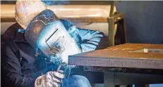  ?? FOTOS: ROLF RUPPENTHAL ?? Ein SHG-Mitarbeite­r glättet die Kanten einer zuvor bearbeitet­en Tafel aus Stahl.