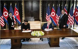  ?? DOUG MILLS/THE NEW YORK TIMES ?? Kim Jong Un of North Korea and President Donald Trump join for a document signing Tuesday in Singapore. They signed what Trump called a “comprehens­ive document.”