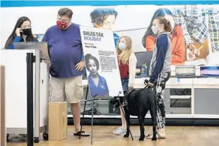  ?? RICARDO RAMIREZ BUXEDA/ORLANDO SENTINEL ?? Sales associate Maria Parra, from left, helps dad Tommy Zeegers, Payton Zeegers, and Hannah Zeegers with Palmer, shop for a laptop at the Alafaya Trail Best Buy store Wednesday.