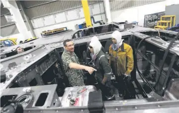  ??  ?? Hishammudd­in (left) talks to technician­s when visiting the Deftech plant in Pekan. — Bernama photo