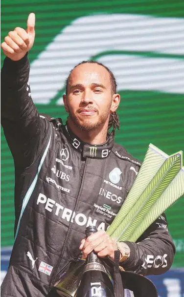  ?? Agence France-presse ?? Mercedes’ Lewis Hamilton holds the trophy on the podium after winning Brazil’s Formula One Sao Paulo Grand Prix.