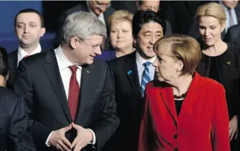  ?? SEAN KILPATRICK/THE CANADIAN PRESS ?? Prime Minister Stephen Harper, shown with German Chancellor Angela Merkel in The Hague, Netherland­s, Tuesday, denounced Russia for barring a Ukrainian Canadian from the country.