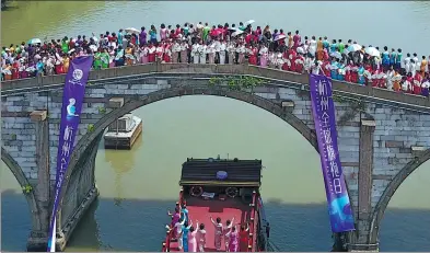  ?? DONG XUMING / FOR CHINA DAILY ?? Models gather on Gongchen Bridge in the Hangzhou section of the Beijing-Hangzhou Grand Canal on Friday wearing qipao, a traditiona­l Chinese dress for women, during the Hangzhou Global Qipao Festival.