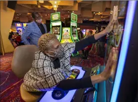  ?? Las Vegas Review-journal @Left_eye_images ?? L.E. Baskow
Noreen Mcroyal gets her hands on a slot machine for extra luck as her husband, Audi, looks about the casino floor during the Virgin Hotels Las Vegas opening.