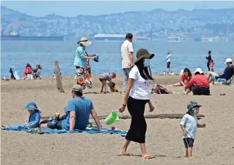  ??  ?? Personas mantienen el distanciam­iento social en la Playa Estatal Robert W. Crown Memorial en California, ayer