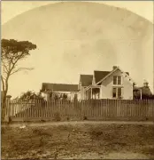  ?? ?? A view of the south and west sides of the Kelley House c. 1880. This early stereoptic­on photograph shows the house, which looks much as it is today, with the kitchen addition on the west, and painted a light color with white trim. An unpainted Mendocino-style picket fence runs along Main Street. The small octagonal building on the left with the staff on the roof is most likely the outhouse. The major difference between this and the present day is the kitchen door on the south porch, which has a small ante-room that is no longer there. The statuary of the Masonic Lodge can be seen on the right side of the image.