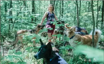  ??  ?? Pomorina poses for a picture with her dogs during a walk outside Moscow.