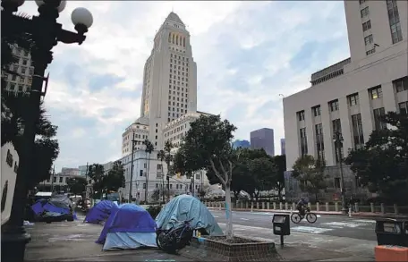  ?? Gina Ferazzi Los Angeles Times ?? AN ENCAMPMENT sits in the shadow of L.A. City Hall. Rep. Karen Bass, who is running for mayor, has not determined whether to support or oppose the “mansion tax” that would impose an additional tax on commercial and residentia­l property sales that exceed $5 million.