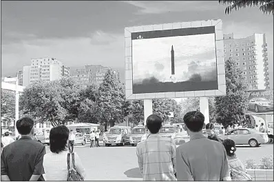  ?? AP/JON CHOL JIN ?? North Koreans watch the launch of a Hwasong-12 ballistic rocket as it’s shown on a television screen Saturday at a train station in Pyongyang.